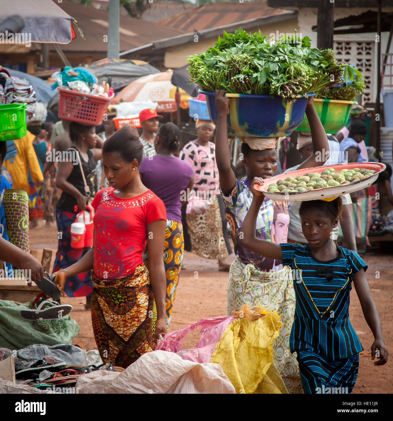 Le donne africane che porta i vassoi e ciotole Foto Stock
