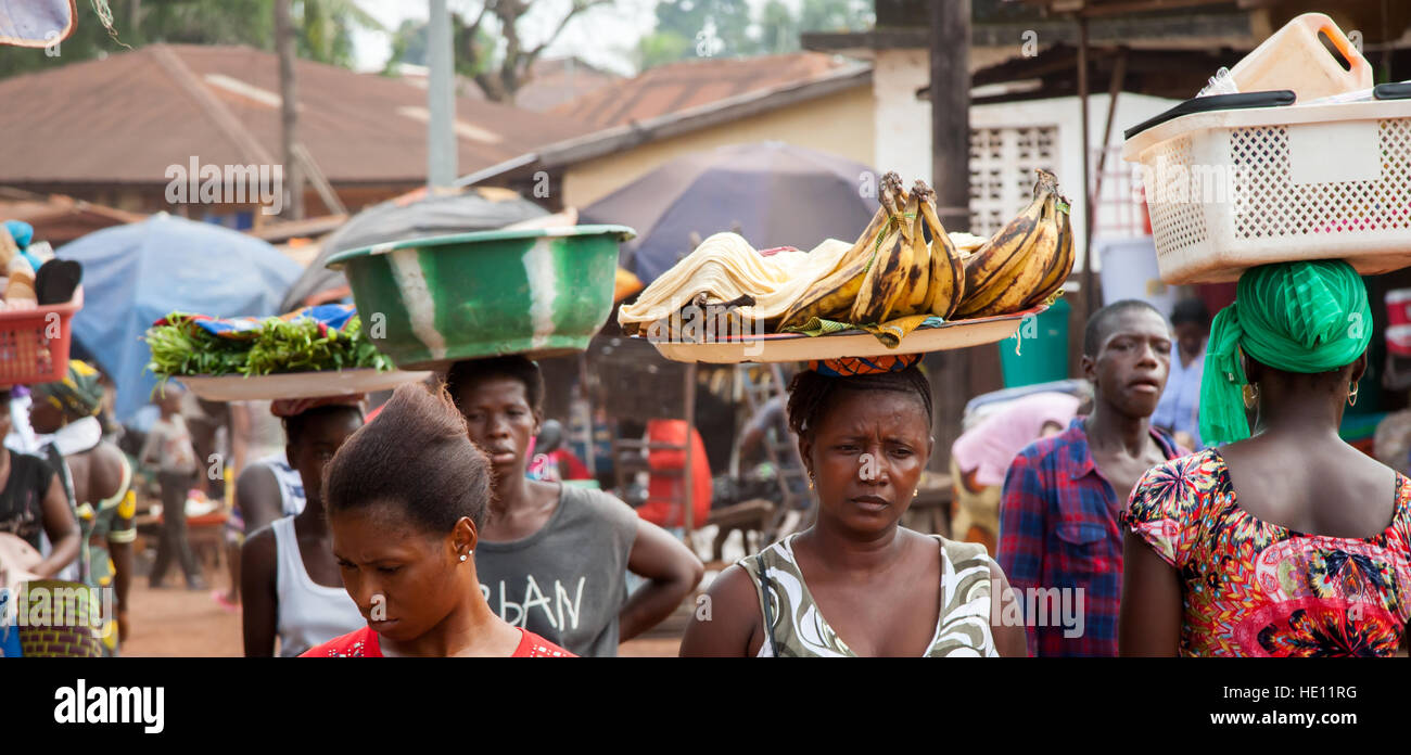 Le donne africane che porta i vassoi e ciotole Foto Stock