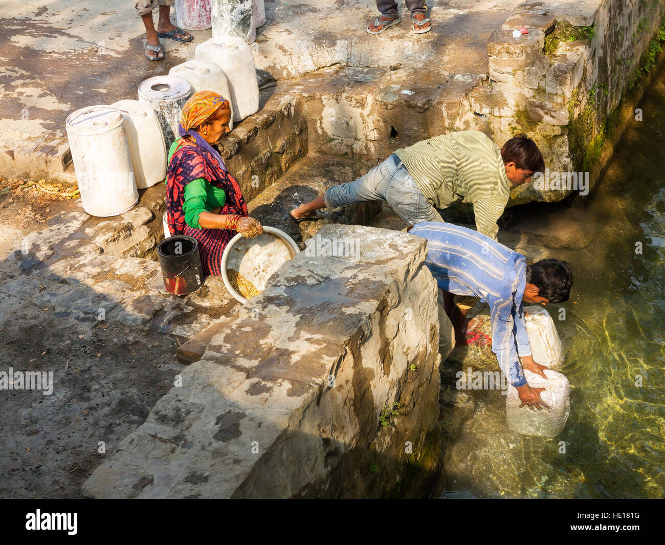 Indian boys recupero acqua a cinghiale canale costruito da Sir Henry Ramsay nel 1860, Chotti Haldwani, Kaladunghi, India Foto Stock
