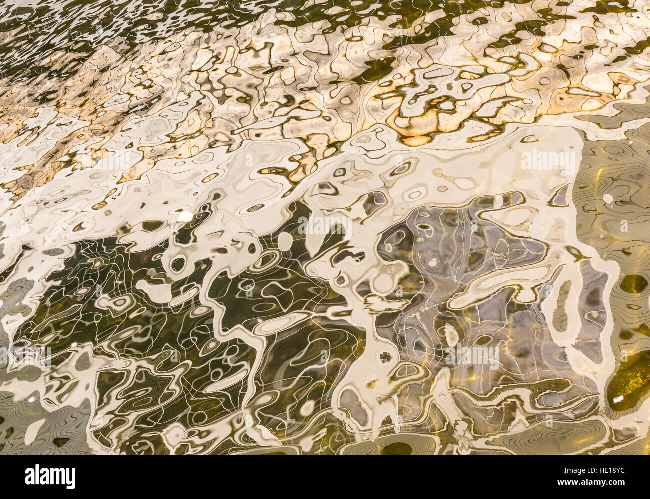 Golden, astratte riflessioni sulla superficie di un lago Foto Stock