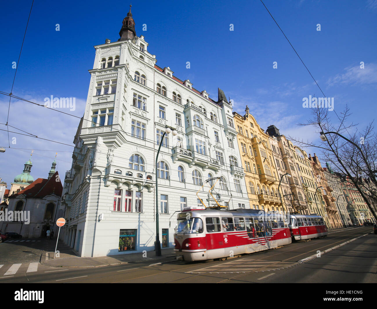 Un tipico tram rosso che passa di fronte all'architettura di Nove Mesto o la Città Nuova di Praga, Repubblica Ceca Foto Stock