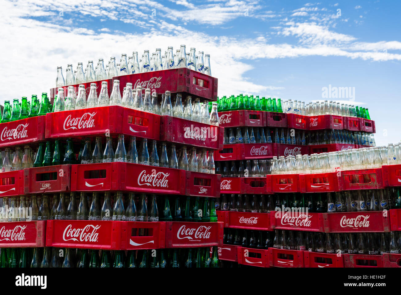 Svuotare la Coca Cola bottiglie in casse sono di accatastamento Foto Stock