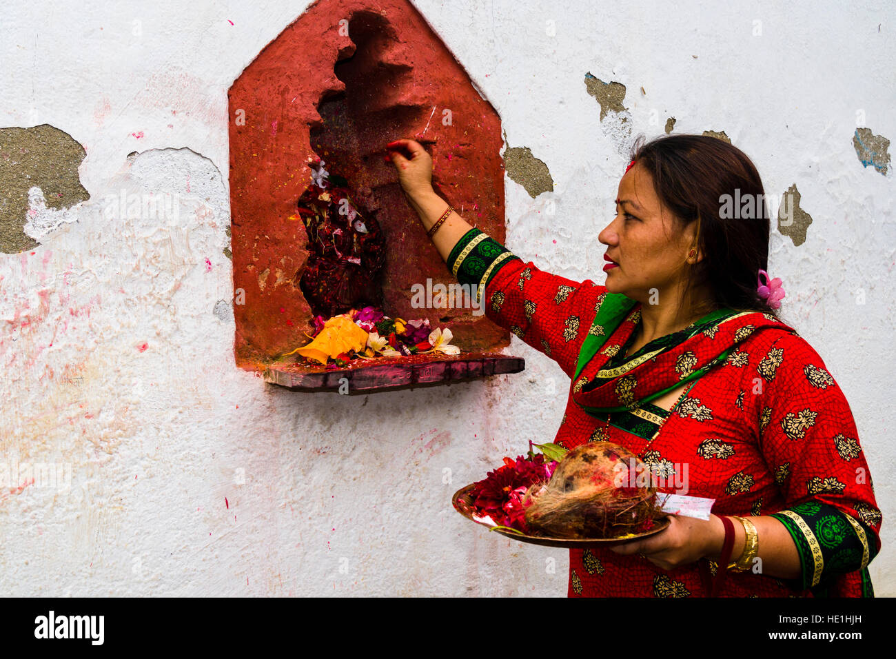 Una donna sta offrendo prasad per le statue di divinità al di fuori del tempio khadga devi mandir presso il festival indù, darsain Foto Stock