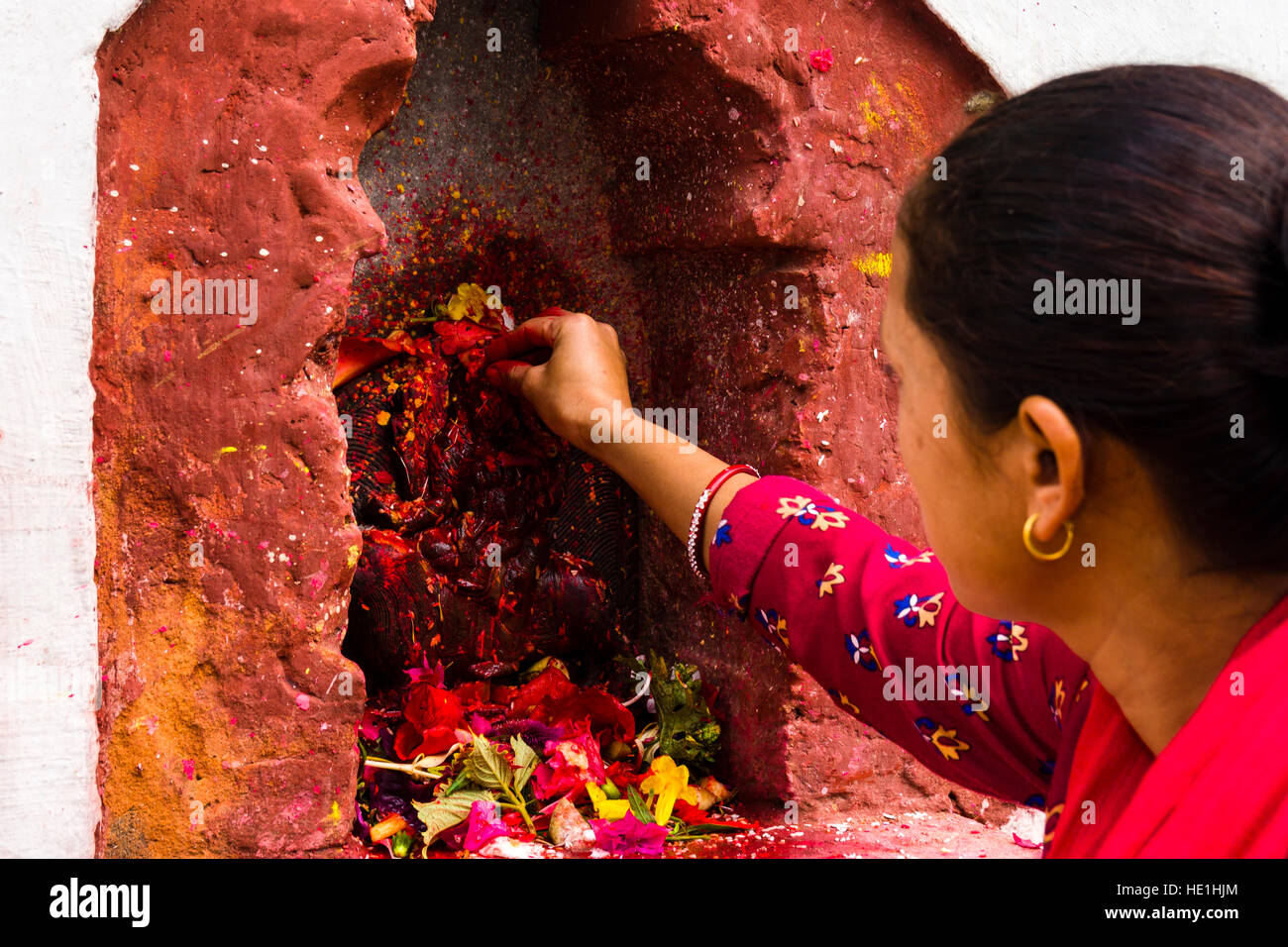 Una donna sta offrendo prasad per le statue di divinità al di fuori del tempio khadga devi mandir presso il festival indù, darsain Foto Stock