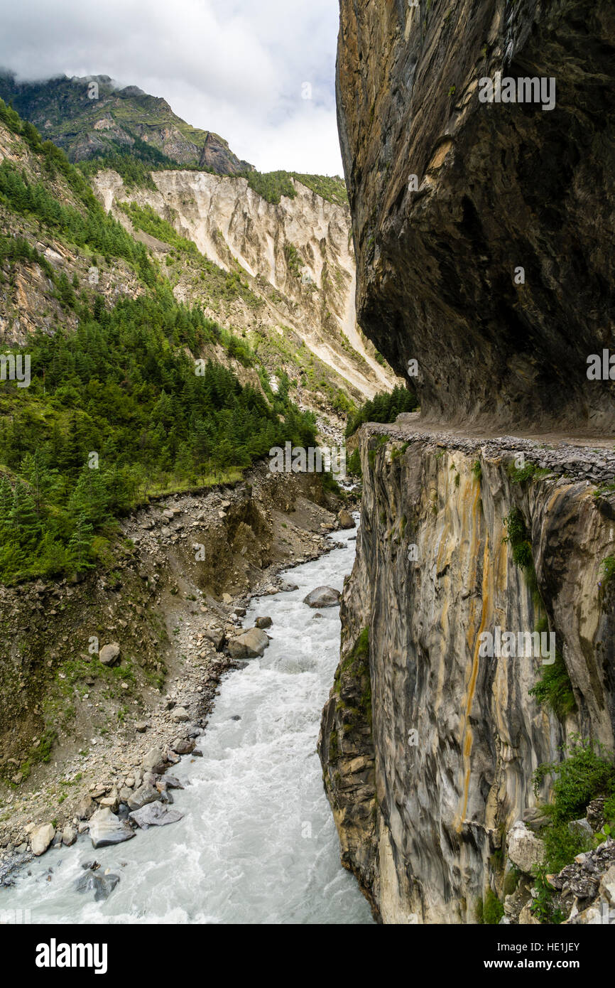 La strada è tagliato in una parete di roccia in alta valle marsyangdi Foto Stock