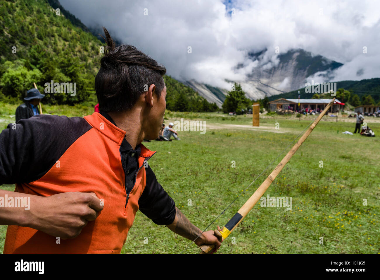 Un uomo locale è la pratica di tiro con l'arco in un villaggio di festa in alta valle Marsyangdi Foto Stock