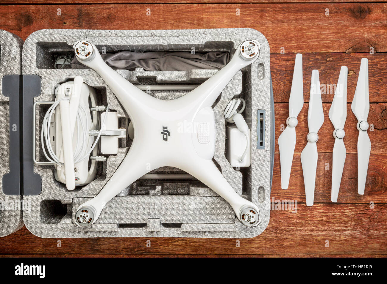 DJI Phantom 4 pro quadcopter drone in una custodia personalizzata su una tavola in legno rustico con una serie di eliche. Foto Stock