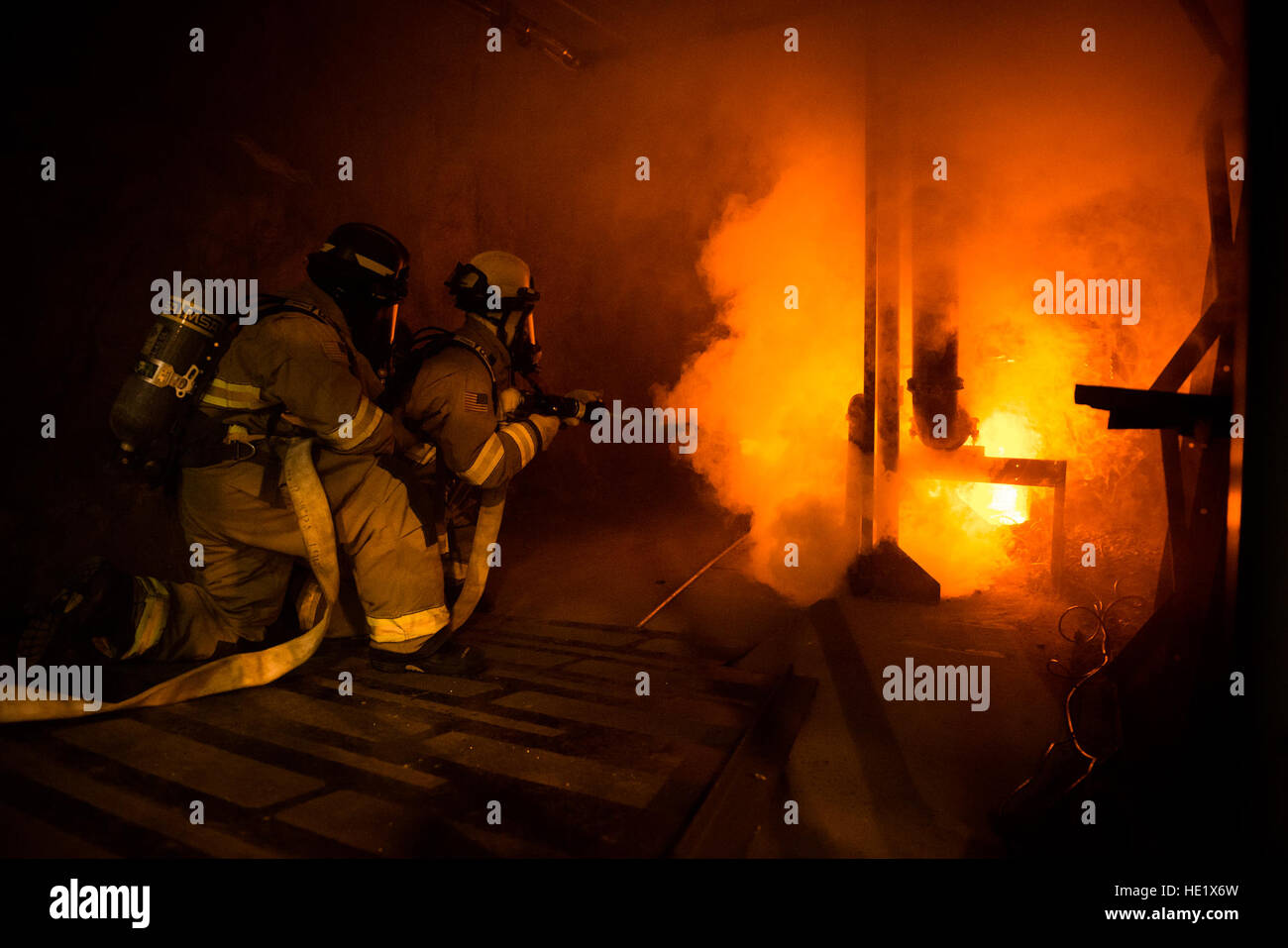 Kenny Geates e Eric Skinner, entrambi i vigili del fuoco con Cheyenne Mountain's Fire e i servizi di emergenza Volo, mettere fuori un incendio simulato in una zona sottostante la struttura durante un esercizio. Con nessuna camera di guidare in tutta la struttura per raggiungere gli incendi, i vigili del fuoco hanno a correre verso di loro. /Staff Sgt. Andrew Lee Foto Stock