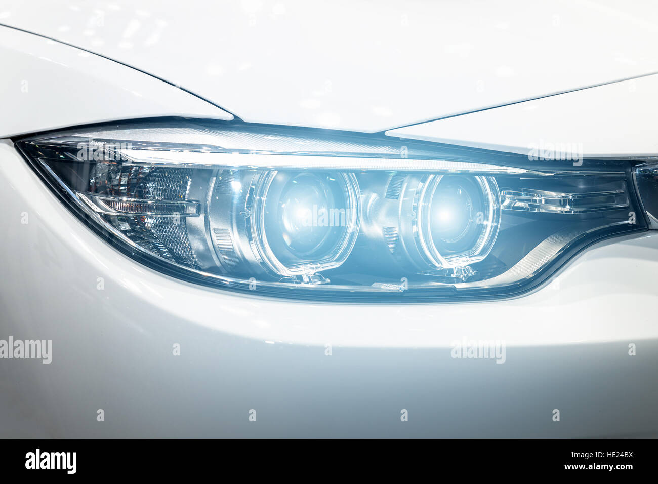 Closeup fari delle automobili moderne nel corso di accendere la luce nella notte. Foto Stock