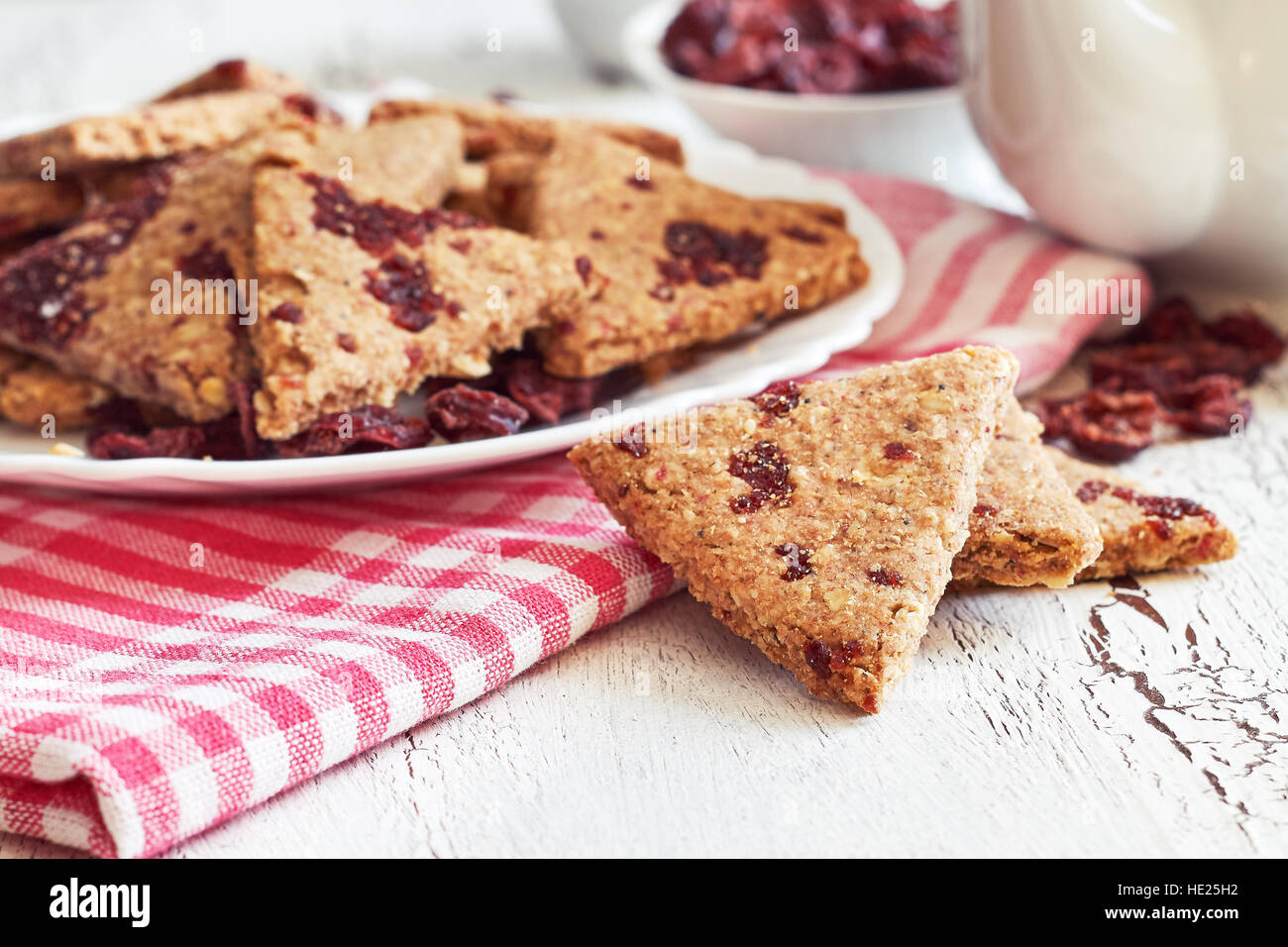Tutto il grano i cookie con mirtilli rossi secchi su bianco rustico sfondo di legno Foto Stock