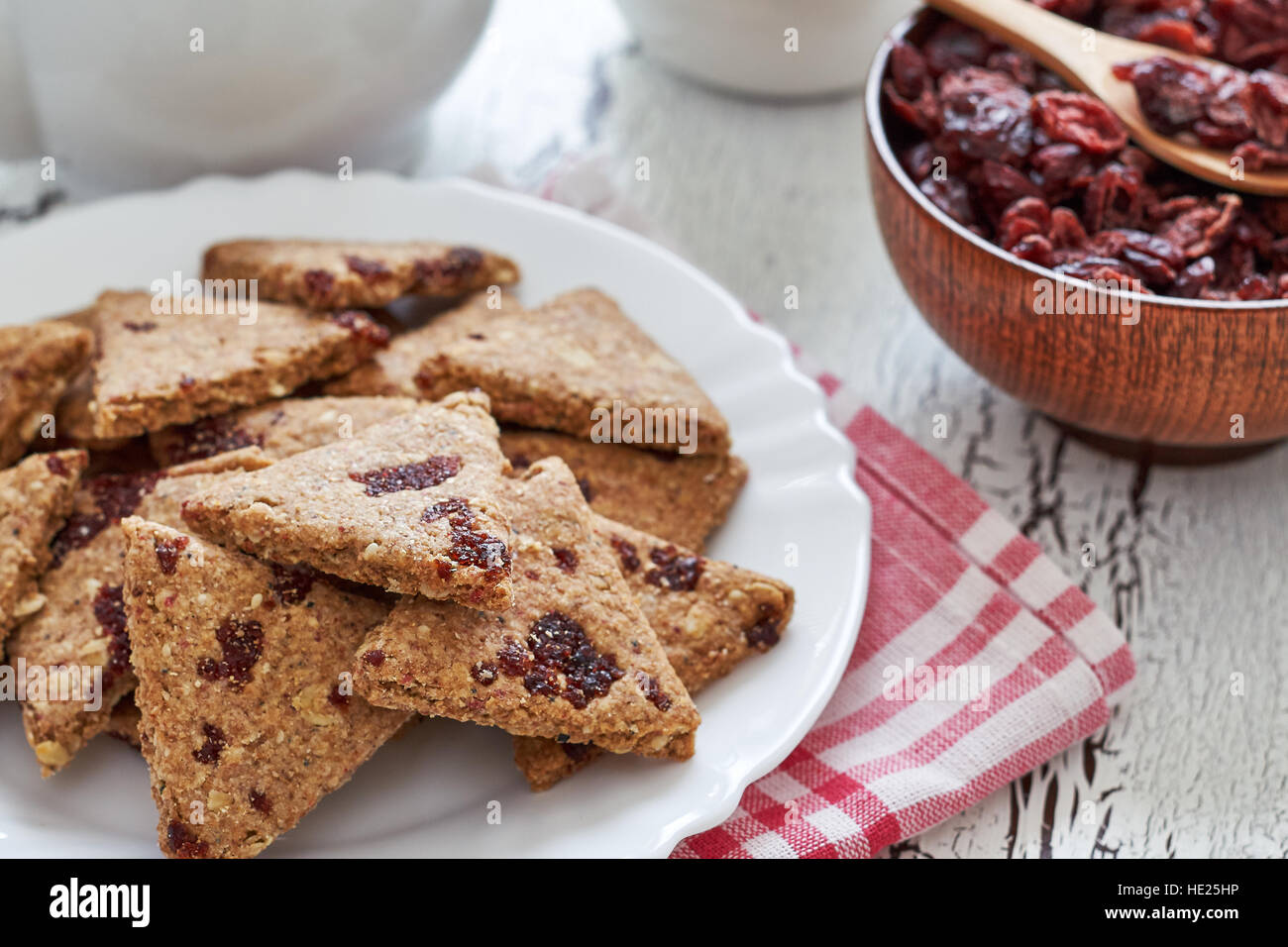 Tutto il grano i cookie con mirtilli rossi secchi su bianco rustico sfondo di legno Foto Stock