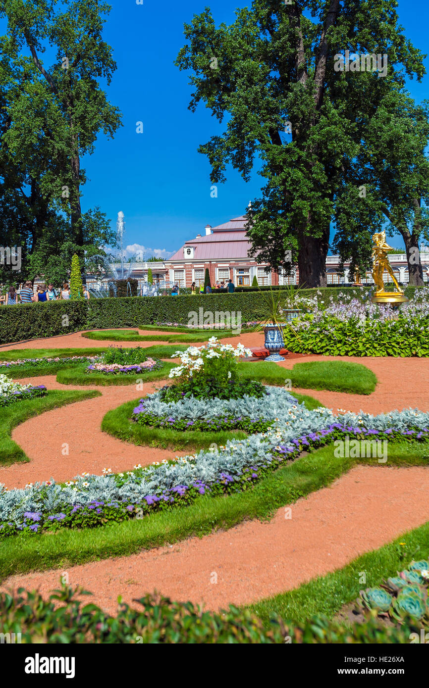 SAINT PETERSBURG, Russia - 27 luglio 2014: i turisti a piedi vicino al Palazzo Monplaisir nella Royal Park con fontane e aiuole di fiori Foto Stock