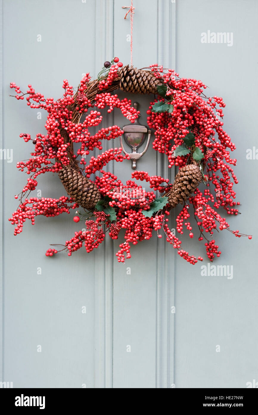Decorativa ghirlanda di Natale appeso sul grigio di una porta anteriore. Foto Stock
