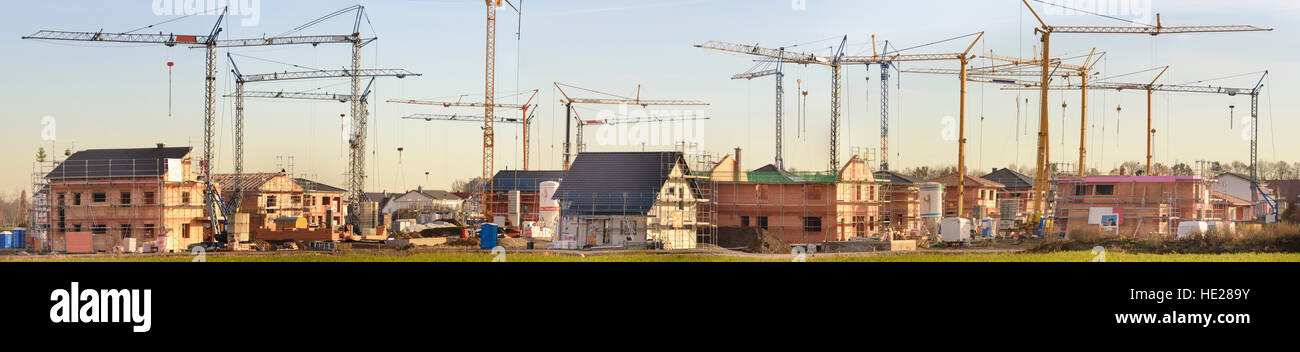 Panorama di molte case residenziali sotto la costruzione di edifici con molte gru Foto Stock