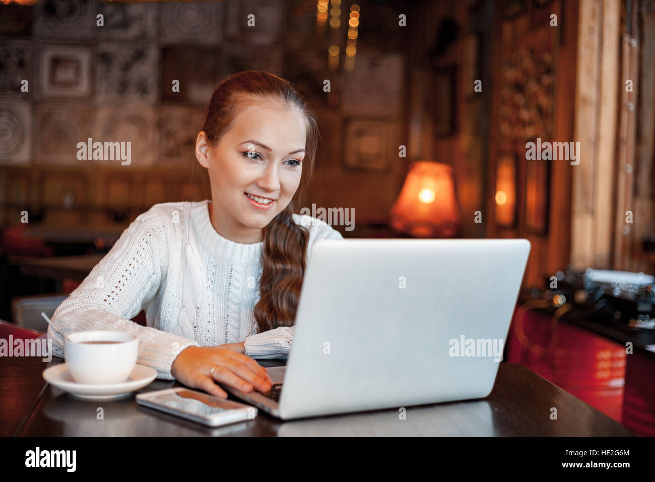 Yong donna un lavoro al computer portatile in cafe Foto Stock