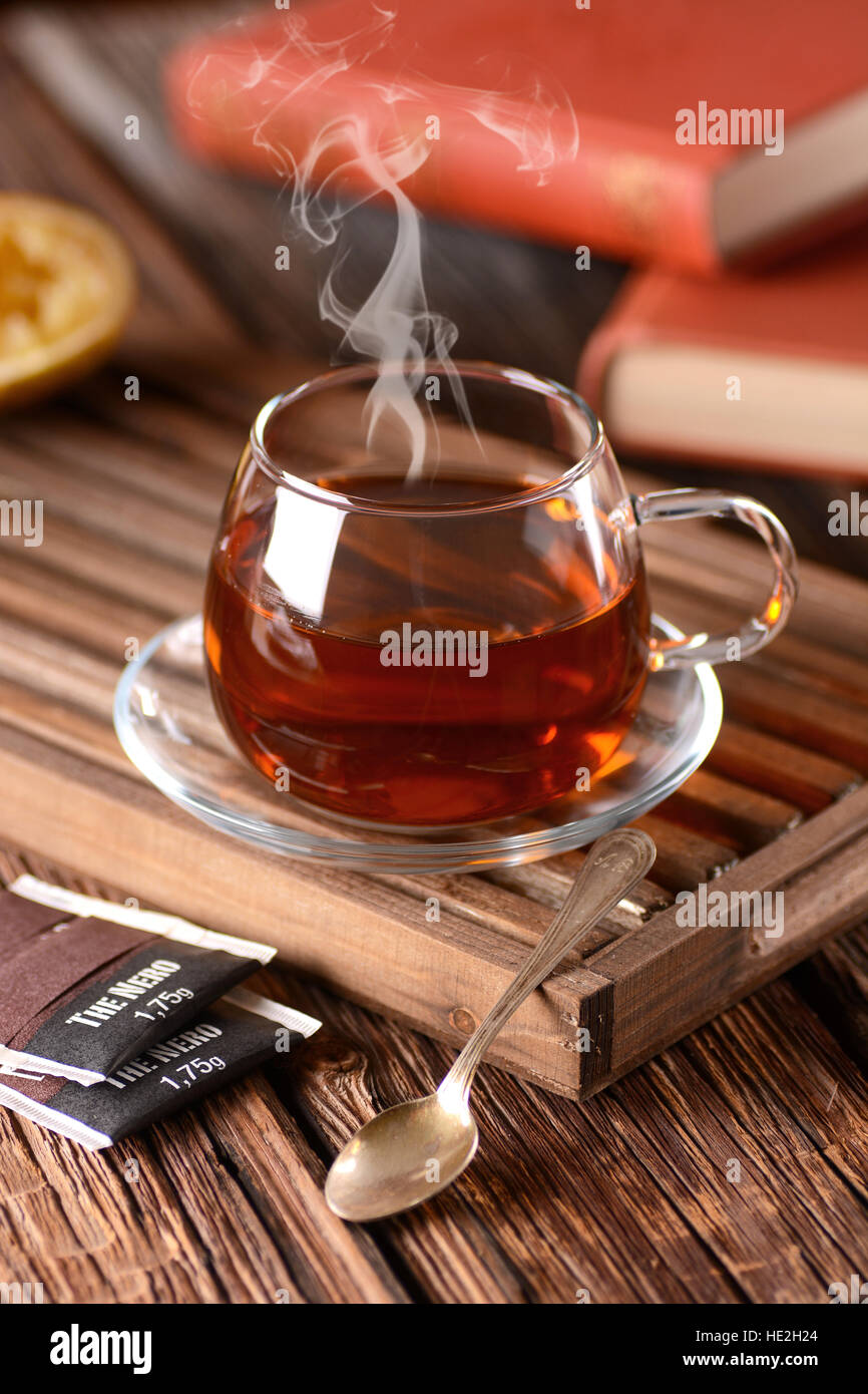 Tè nero in tazza di vetro sul vassoio in legno Foto Stock