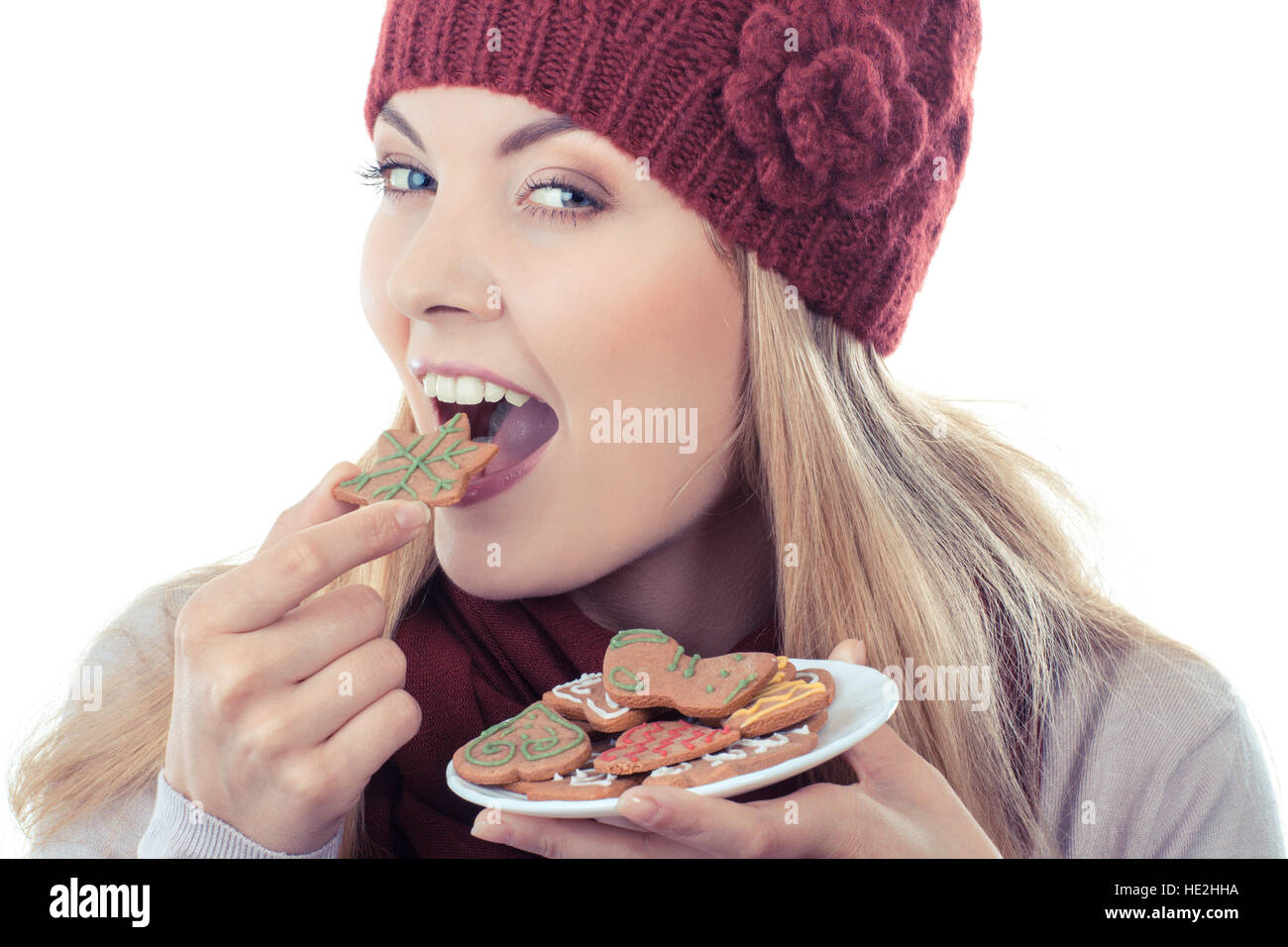 Foto d'epoca, sorridenti donna che indossa cappello di lana e scialle e azienda gingerbreads o cookie di festosa, tempo di Natale, sfondo bianco Foto Stock