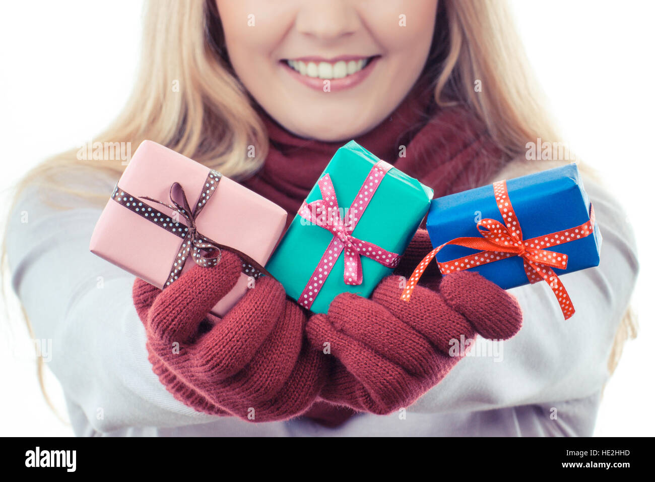 Foto d'epoca, donna sorridente in guanti di lana avvolto di contenimento di regali di Natale, Valentino, compleanno o altra celebrazione, sfondo bianco Foto Stock
