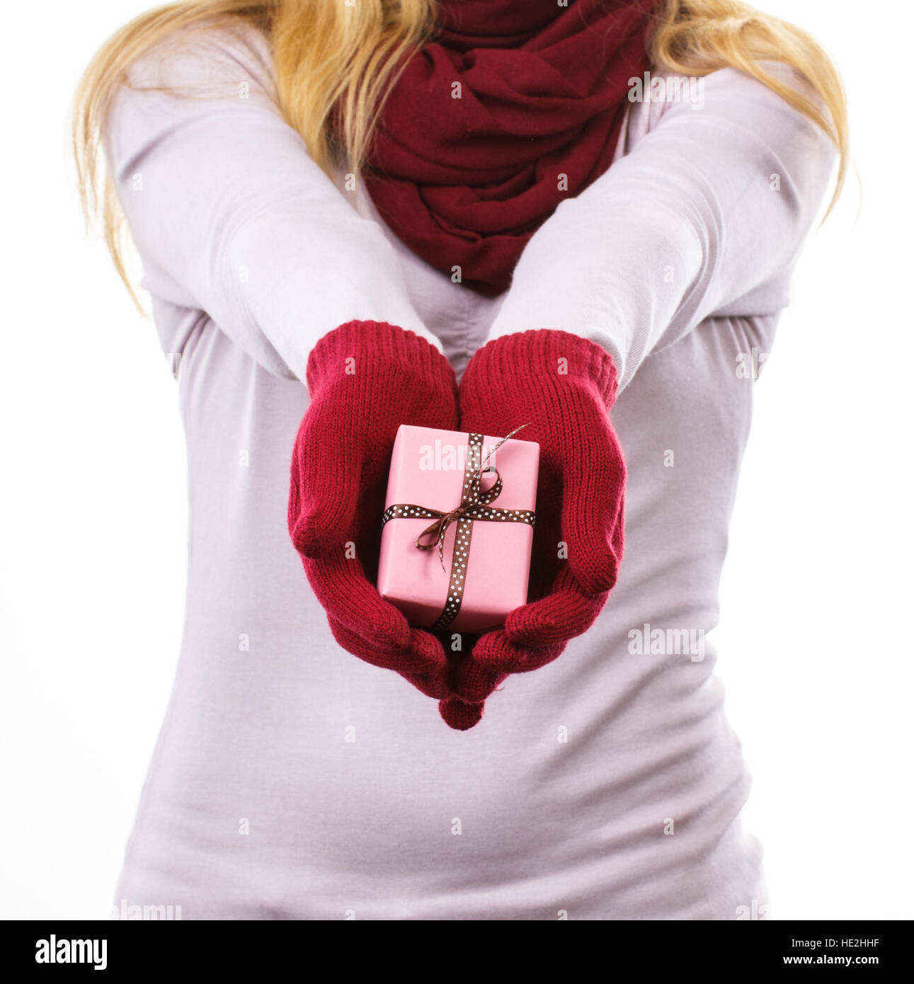 La mano della donna nei guanti di lana avvolto di contenimento regalo per Natale, Valentino, compleanno o altra celebrazione Foto Stock