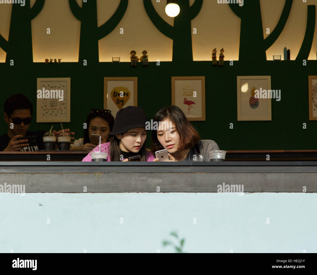 Busan, Corea del Sud - Settembre 10th, 2016: Busan, area Gamcheon, i visitatori di street cafe guardare al telefono della ditta Apple. Foto Stock
