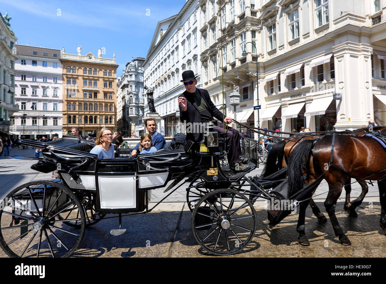 AUSTRIA, VIENNA - 14 Maggio 2016: Foto vista sui turisti su carrello con cavalli neri e driver in area centrale intorno al palazzo imperiale Hofburg Foto Stock