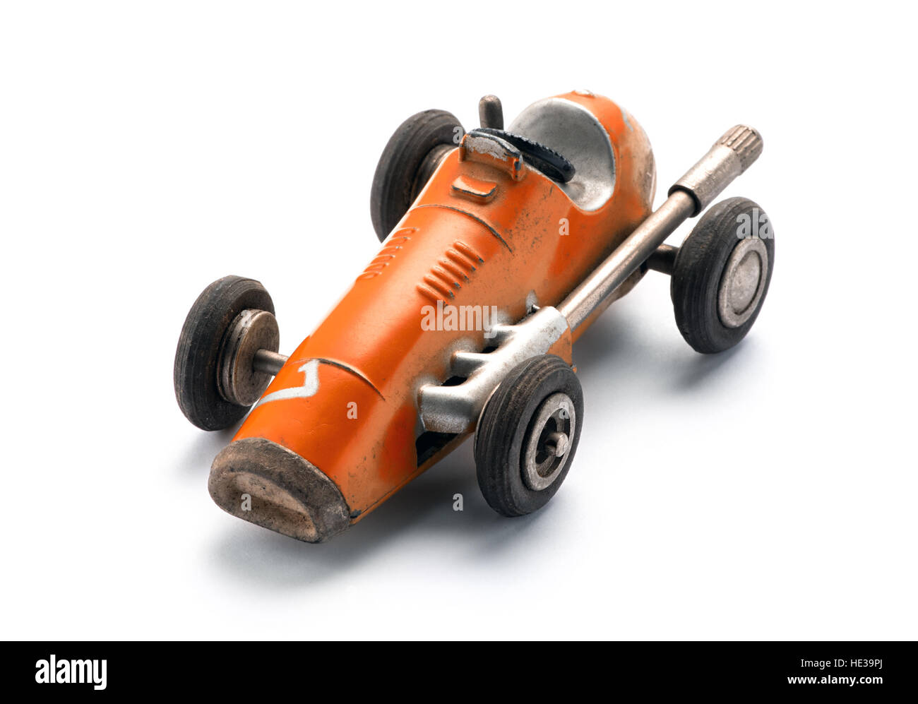 Colorato arancione giocattolo vintage racing auto in una di tre quarti anteriore, vista da sopra su uno sfondo bianco con spazio di copia Foto Stock