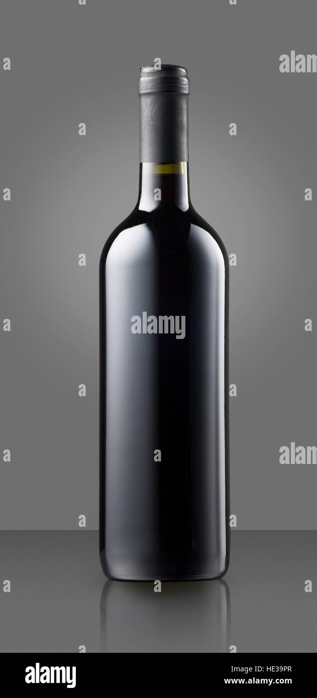 Blank full capped vino rosso bottiglia sul grigio con copia spazio per una etichetta o marchio per una cantina Foto Stock