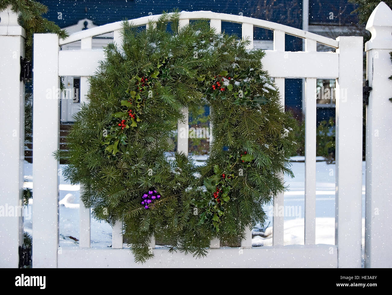 Ghirlanda di pino con decorazioni di Natale su bianco cancello di recinzione Foto Stock