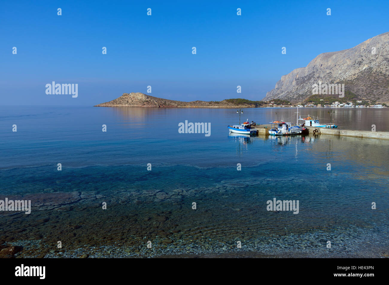 Telendos Island da Myrties Jetty, Kalymnos, mare blu con piccole imbarcazioni Foto Stock