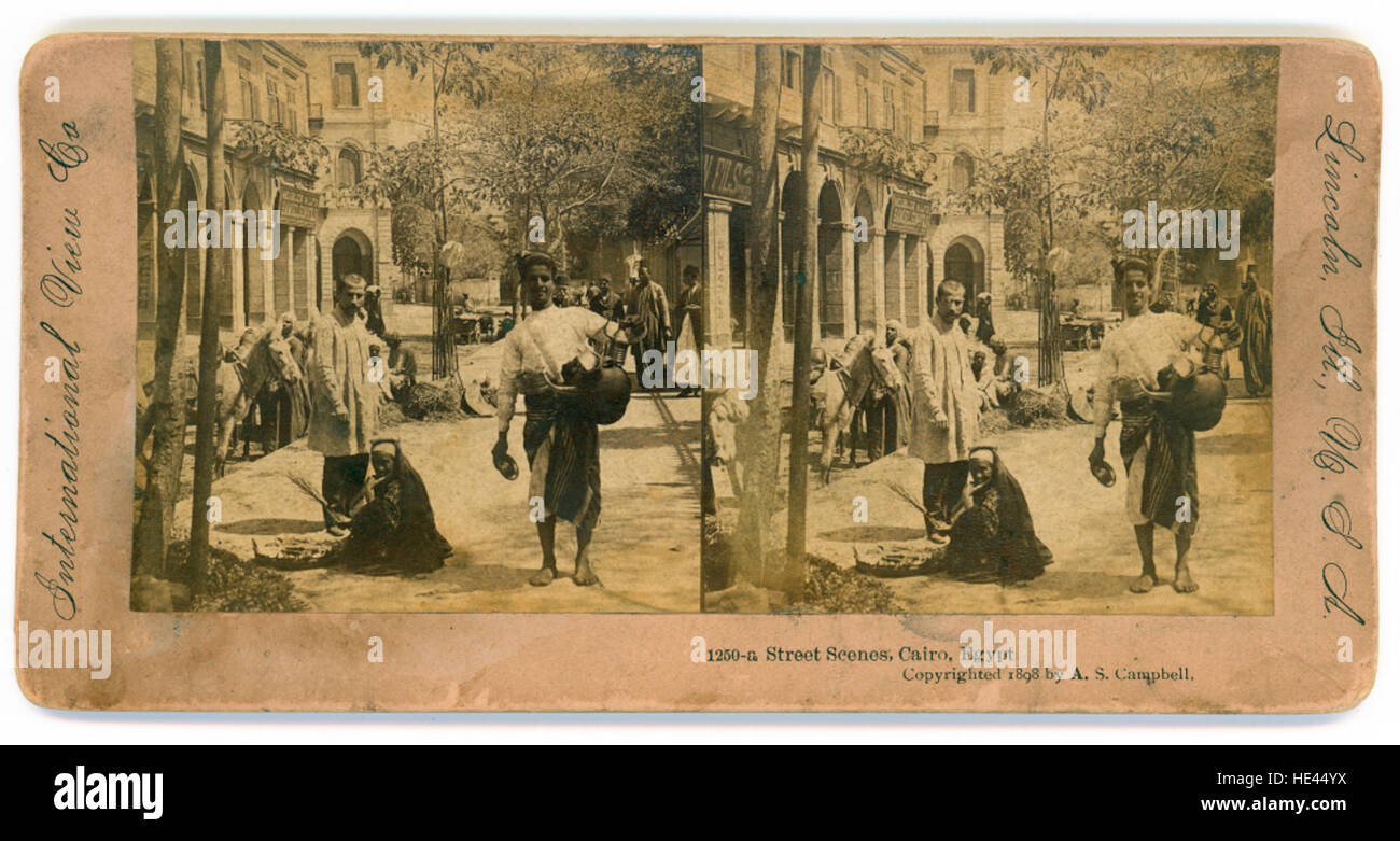 Questa fotografia storica di scene di strada al Cairo, in Egitto, mostra la vita vivace e il paesaggio architettonico della città in passato, mettendo in evidenza sia le attività quotidiane che l'ambiente urbano. Foto Stock