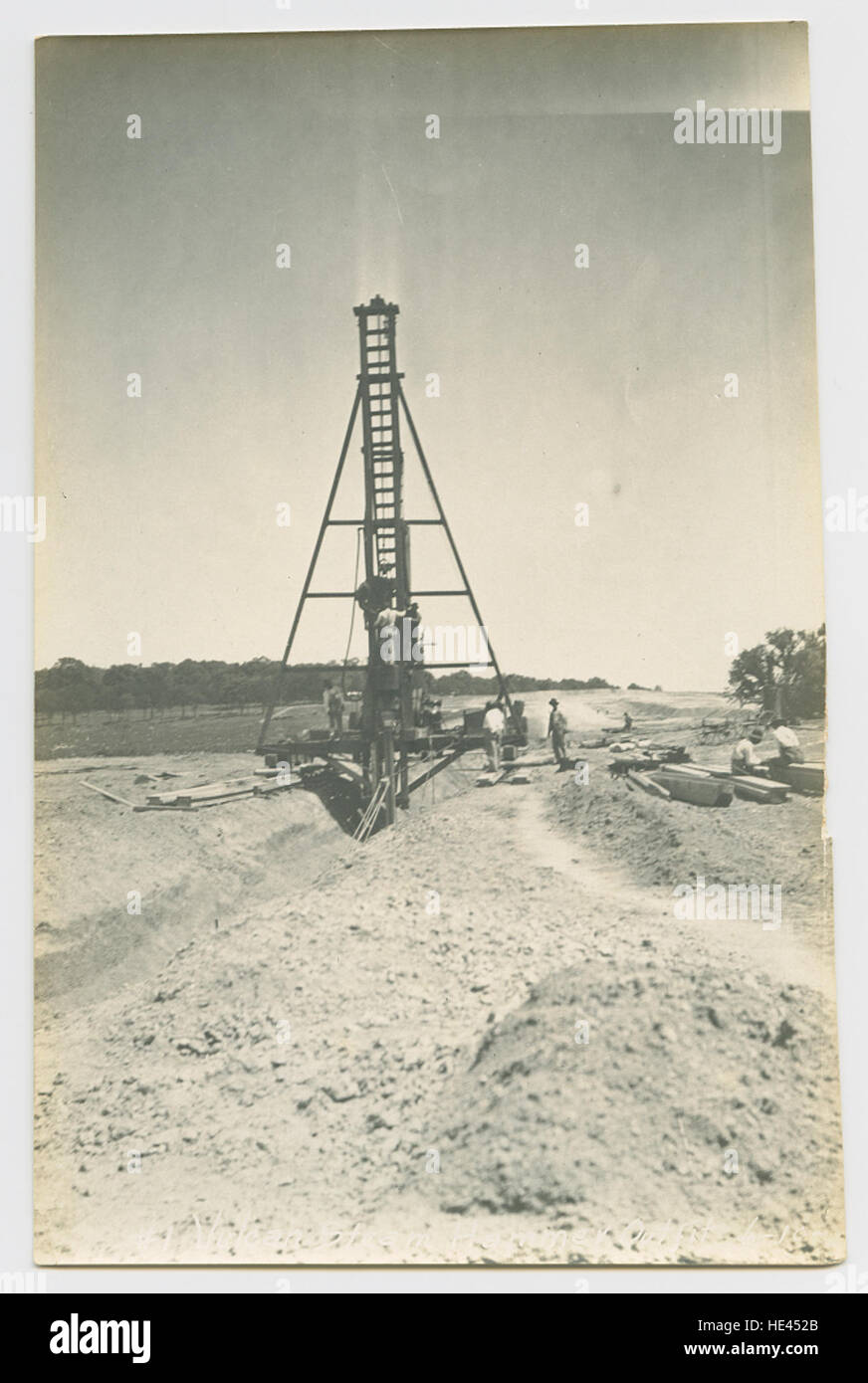 Il Vulcan Hammer Outfit è stato utilizzato nella costruzione di grandi progetti infrastrutturali, in particolare dighe e bacini idrici. Questa immagine vintage cattura i macchinari e i lavoratori coinvolti nella definizione delle infrastrutture critiche, evidenziando gli sforzi di progettazione e processo impegnativi necessari per tali progetti monumentali in Texas, tra cui il lago White Rock. Foto Stock