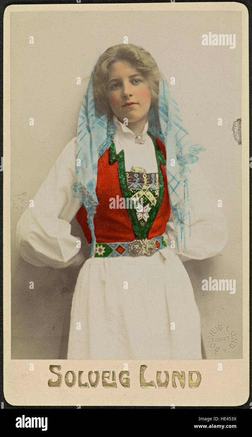 Questo storico ritratto in studio presenta una donna non identificata che indossa il tradizionale bunad norvegese, un costume nazionale. Catturato nel XIX o all'inizio del XX secolo, mette in risalto il patrimonio culturale della Norvegia. L'immagine riflette la moda e le usanze sociali del periodo, fornendo un'idea dell'uso storico dei costumi popolari nell'identità norvegese. Foto Stock