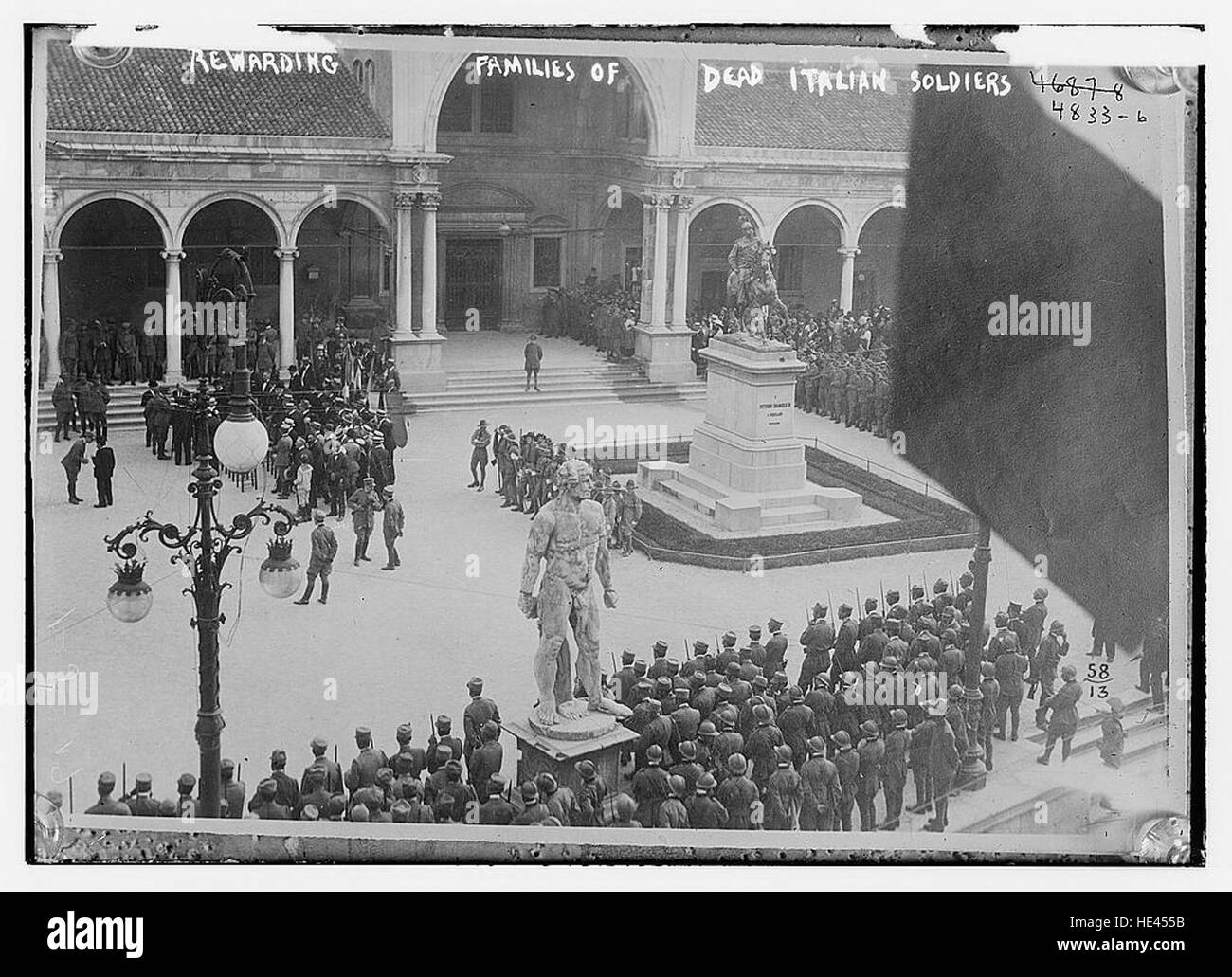 Questa immagine storica raffigura una cerimonia in cui vengono onorate le famiglie dei soldati italiani deceduti. La cerimonia riflette il riconoscimento cupo e rispettoso dei sacrifici fatti dai soldati durante la guerra. Foto Stock