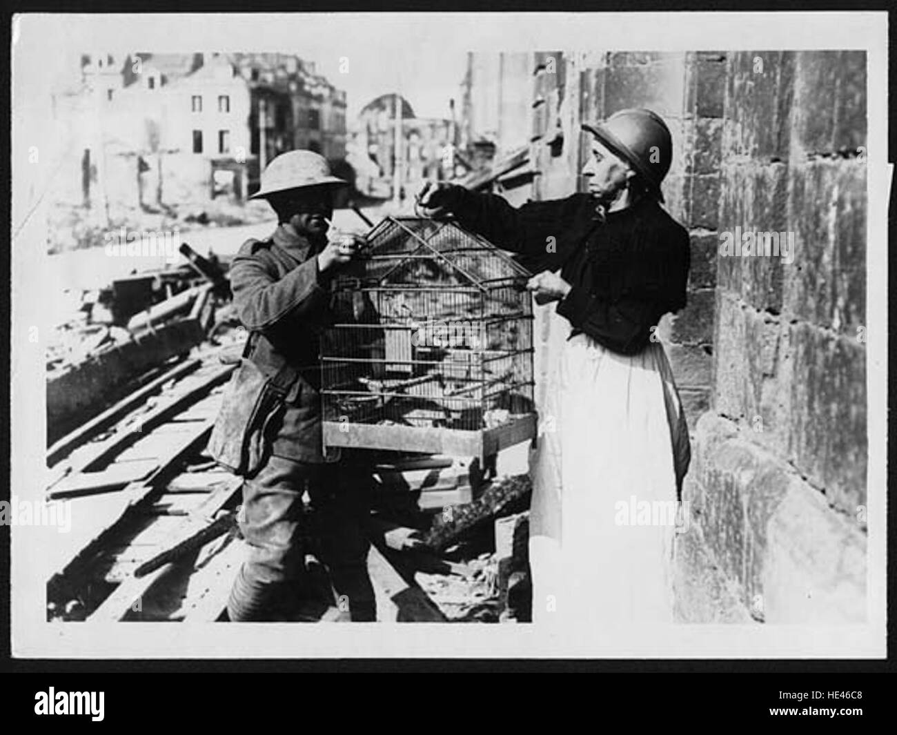 Questa commovente immagine raffigura un'anziana donna francese durante un'evacuazione in tempo di guerra ad Amiens. Viene vista lasciare la sua casa, stringere il suo amato animale domestico, un momento di perdita e incertezza durante lo sconvolgimento della guerra. Foto Stock