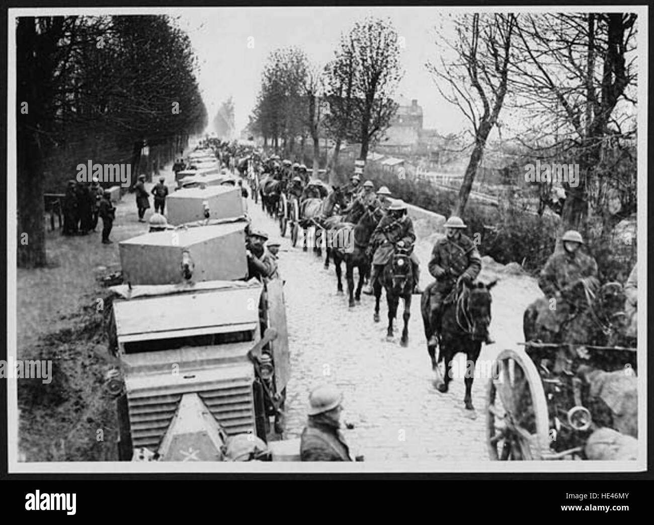 Un'immagine storica che raffigura auto corazzate francesi e veicoli da trasporto britannici che avanzano in Francia durante un conflitto passato, mostrando veicoli militari in tempo di guerra. Foto Stock