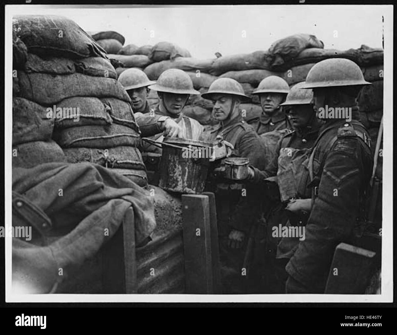 Questa immagine storica raffigura soldati che servono stufato in una trincea in prima linea della prima guerra mondiale. Mette in evidenza la vita quotidiana e le difficoltà affrontate dai soldati durante la guerra, sottolineando l'aspetto umano della guerra. Foto Stock Questa immagine storica raffigura soldati che servono stufato in una trincea in prima linea della prima guerra mondiale. Mette in evidenza la vita quotidiana e le difficoltà affrontate dai soldati durante la guerra, sottolineando l'aspetto umano della guerra. Foto Stock