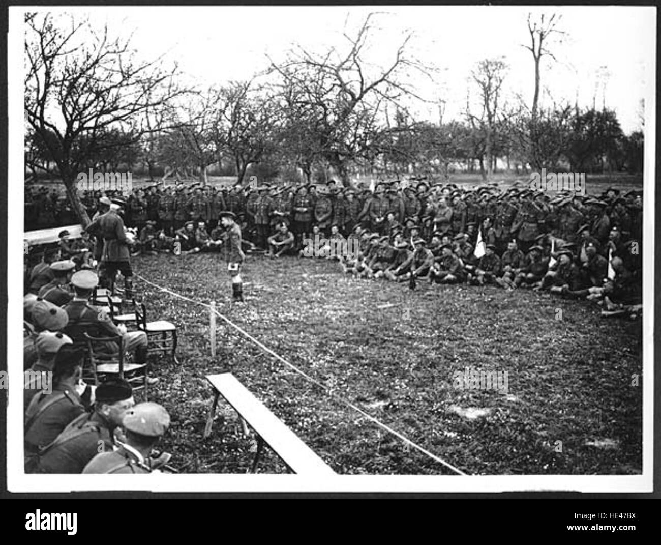 Questa immagine storica cattura un Comandante Divisionale che distribuisce premi, probabilmente da un evento militare o sociale passato. La scena riflette una cerimonia formale, che simboleggia il riconoscimento dei risultati, sia nello sport, nel servizio militare o negli eventi della comunità, evidenziando le tradizioni di ricompensa e riconoscimento. Foto Stock