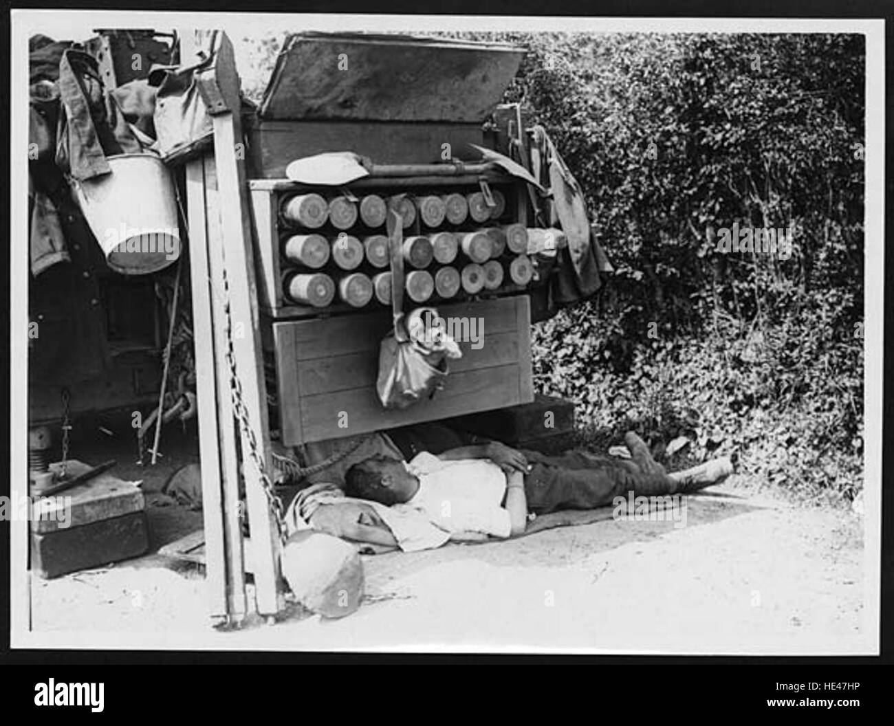 Questa immagine cattura un soldato (cannoniere) che riposa mentre è ancora in servizio. La fotografia riflette l'aspetto umano della vita militare, illustrando l'equilibrio tra riposo e prontezza necessaria nelle situazioni di combattimento. Foto Stock