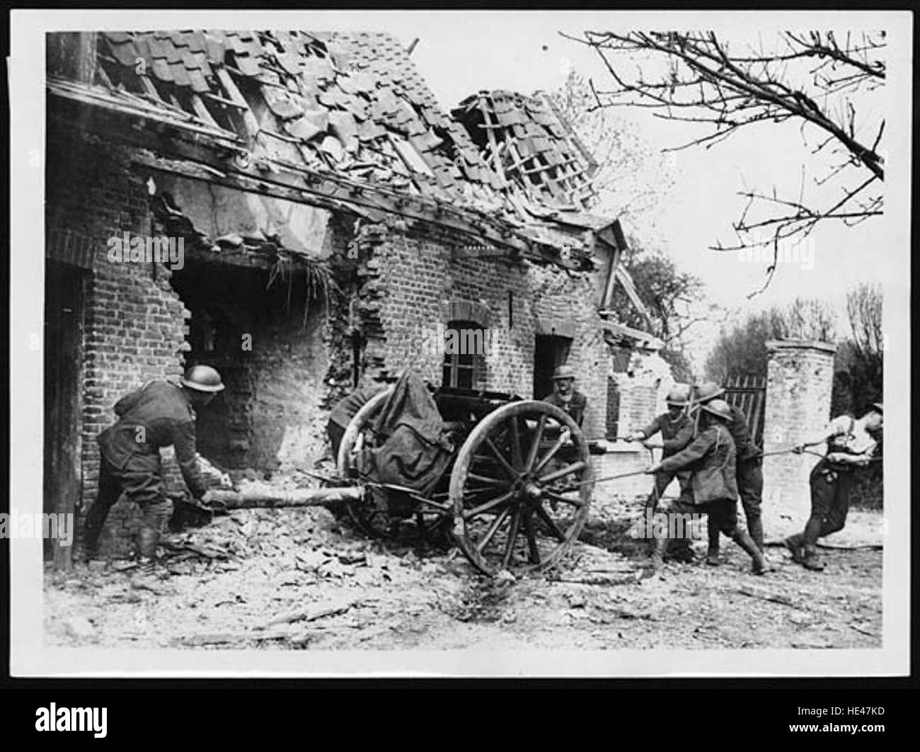Questa immagine storica cattura una pistola da campo che viene messa in azione accanto a un cottage in rovina, evocando l'atmosfera della guerra e del passato, mostrando la durezza del tempo. Foto Stock Questa immagine storica cattura una pistola da campo che viene messa in azione accanto a un cottage in rovina, evocando l'atmosfera della guerra e del passato, mostrando la durezza del tempo. Foto Stock