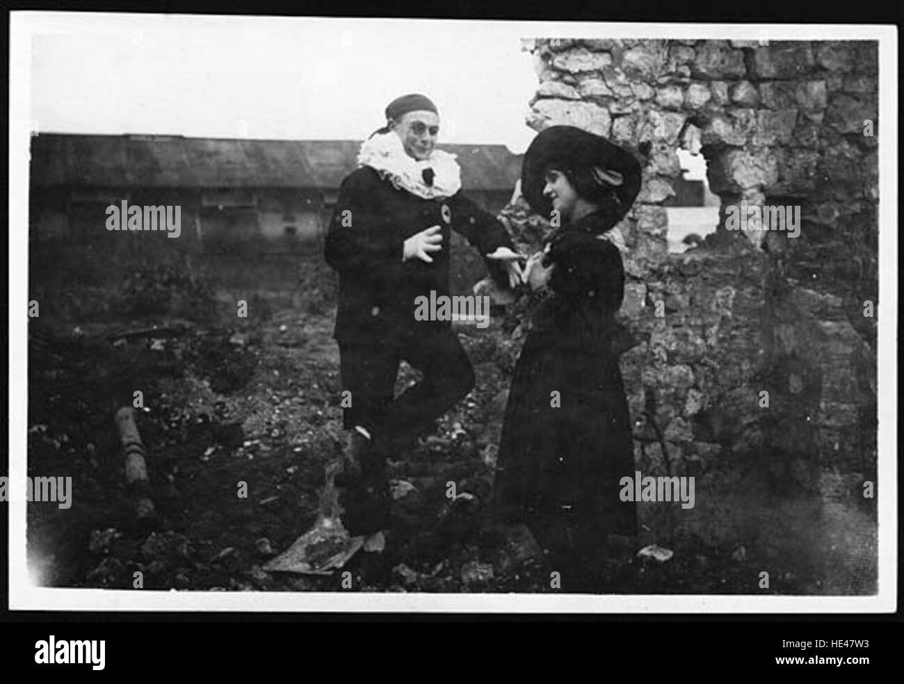 Una fotografia storica che mostra un eroe e una ragazza che provano una scena tra antiche rovine. L'immagine cattura la giustapposizione della storia antica con la pratica teatrale moderna. Foto Stock