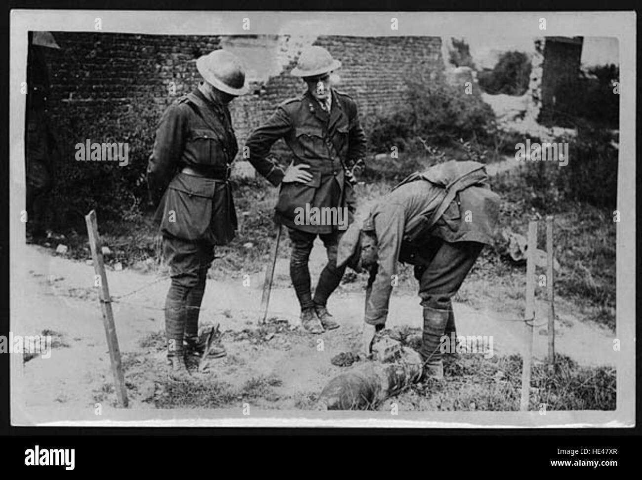 Questa immagine illustra un momento storico in cui il personale militare adotta misure precauzionali contro gli ordigni inesplosi, mettendo in evidenza l'importanza della sicurezza nelle operazioni in tempo di guerra. Foto Stock
