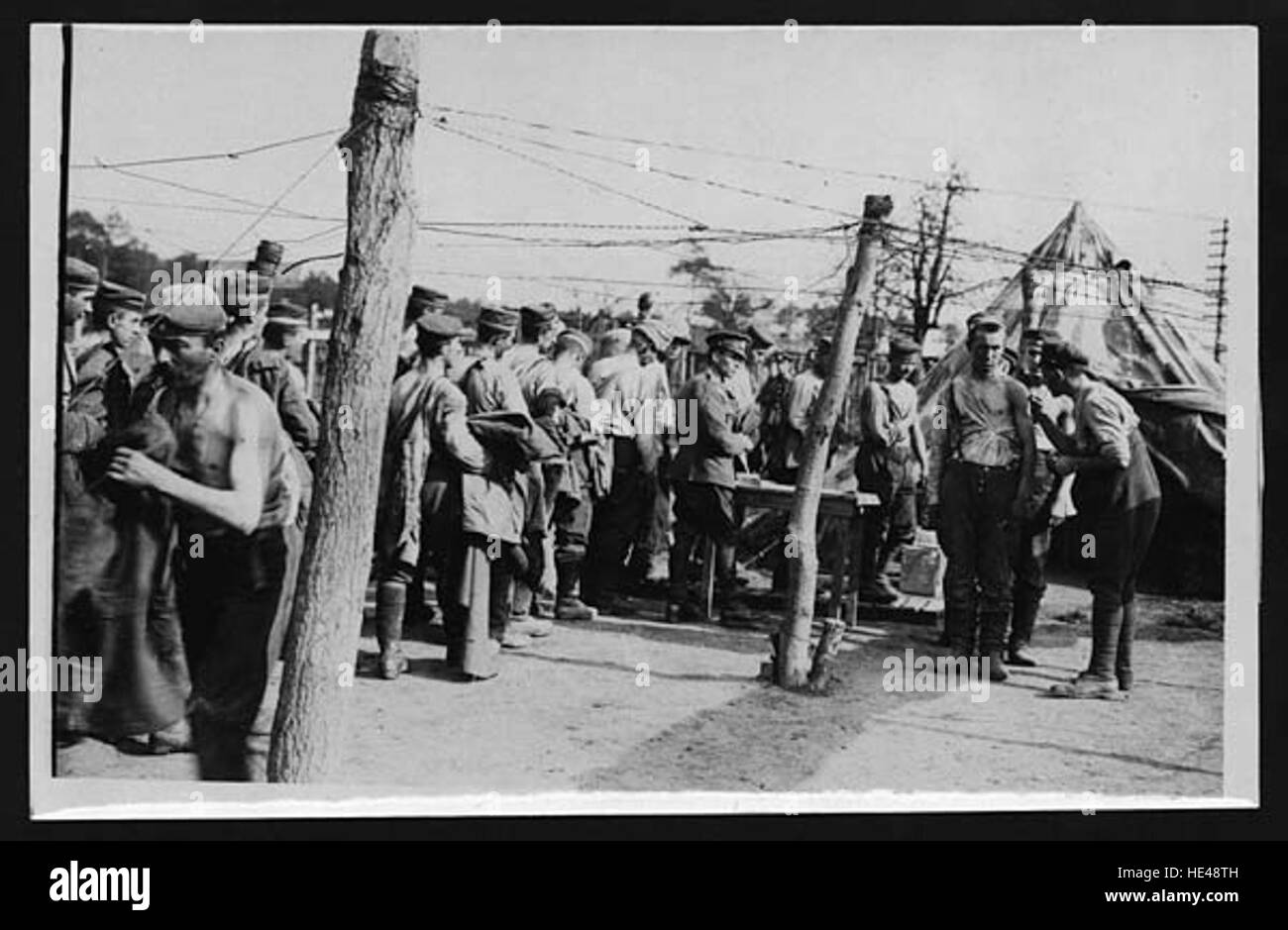 Questa immagine storica mostra i prigionieri tedeschi vaccinati, probabilmente durante o dopo la seconda guerra mondiale. La fotografia cattura un momento della storia in cui sono state applicate misure di salute pubblica per prevenire la diffusione di malattie nei campi o nelle regioni devastate dalla guerra. Foto Stock