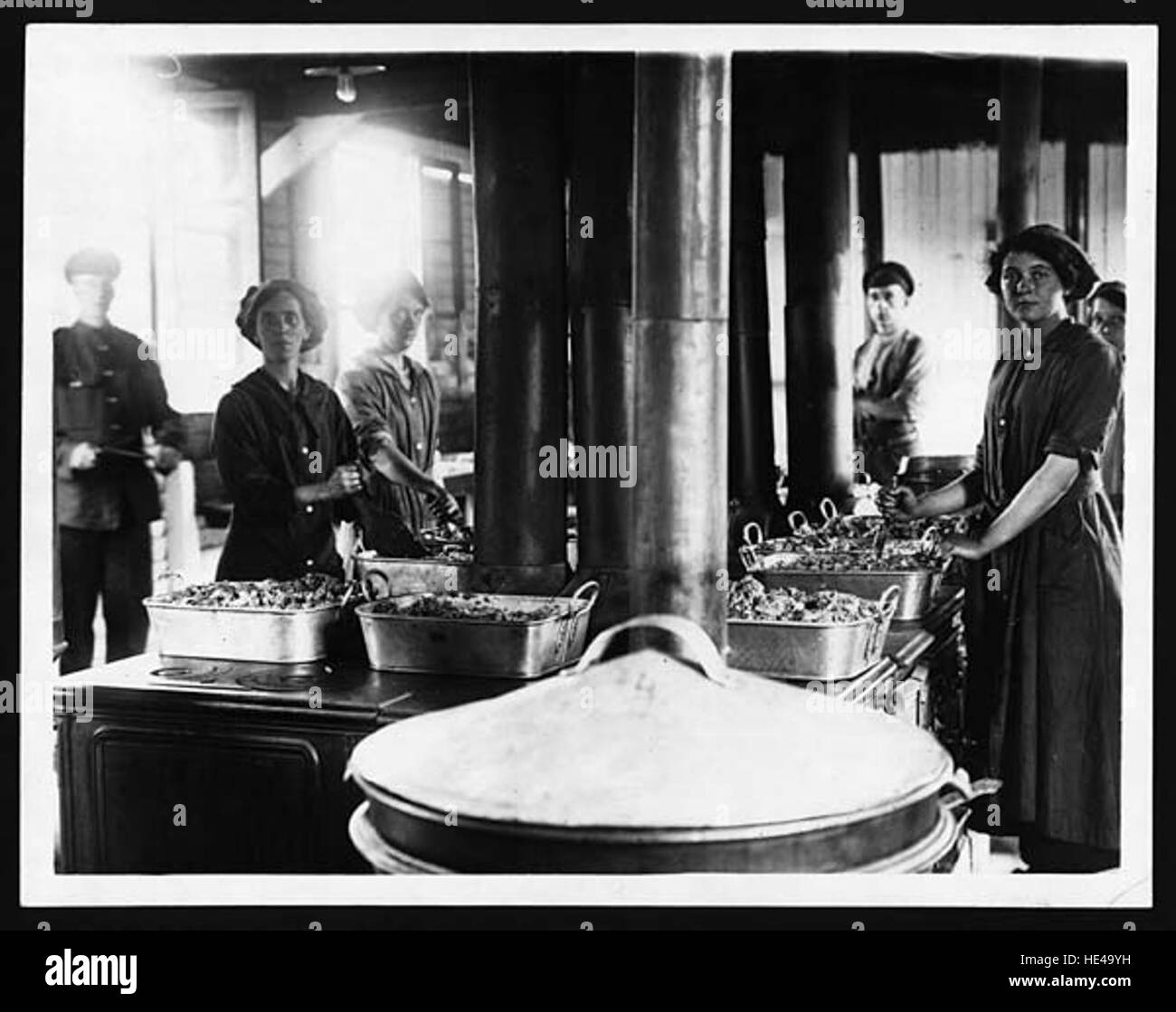 Questa immagine storica della prima guerra mondiale mostra le cuoche donne in prima linea, un ruolo significativo che hanno assunto durante la guerra. Con gli uomini schierati in combattimento, le donne contribuirono ai servizi di supporto essenziali, tra cui cucinare e fornire pasti ai soldati, evidenziando il loro inestimabile contributo allo sforzo bellico. Foto Stock