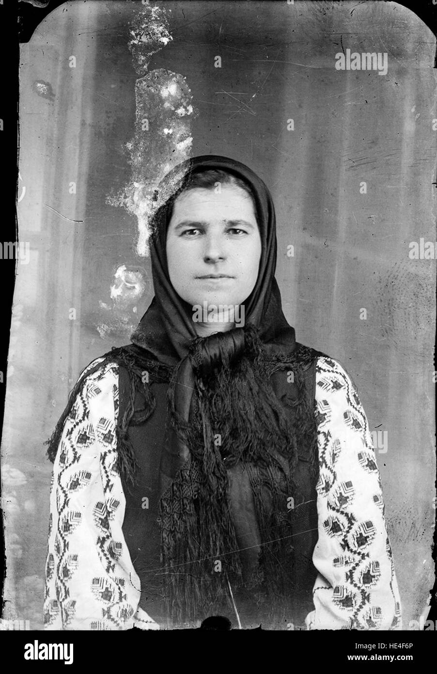 Un ritratto di una giovane donna in costume tradizionale rumeno, catturato in una fotografia su lastra di vetro, che riflette la ricchezza culturale della Romania all'inizio del XX secolo. Foto Stock