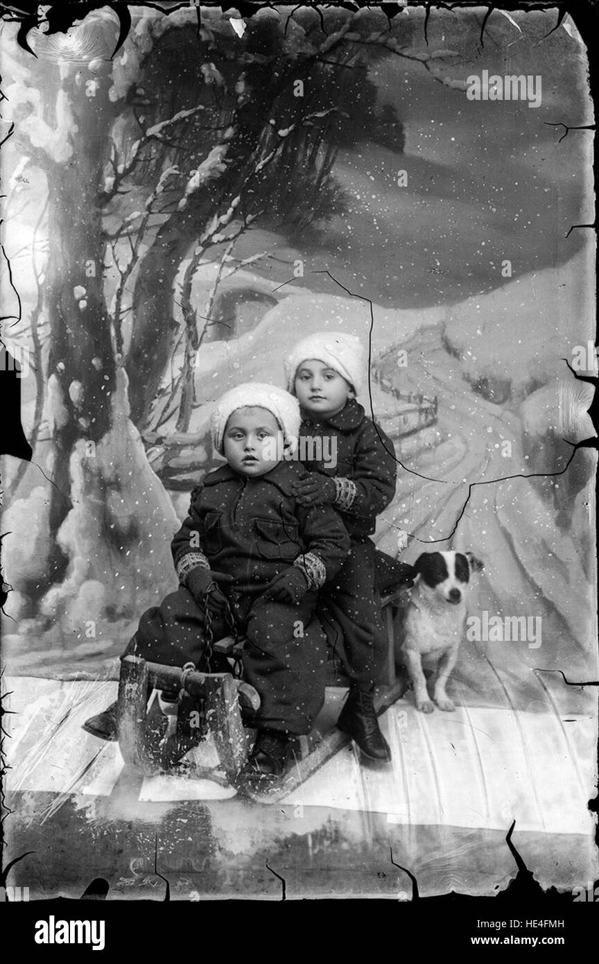 Due bambini su una slitta con un cane, neve chimica, dall'Archivio Costica Acsinte, Ialomita, Romania, lastra di vetro Foto Stock
