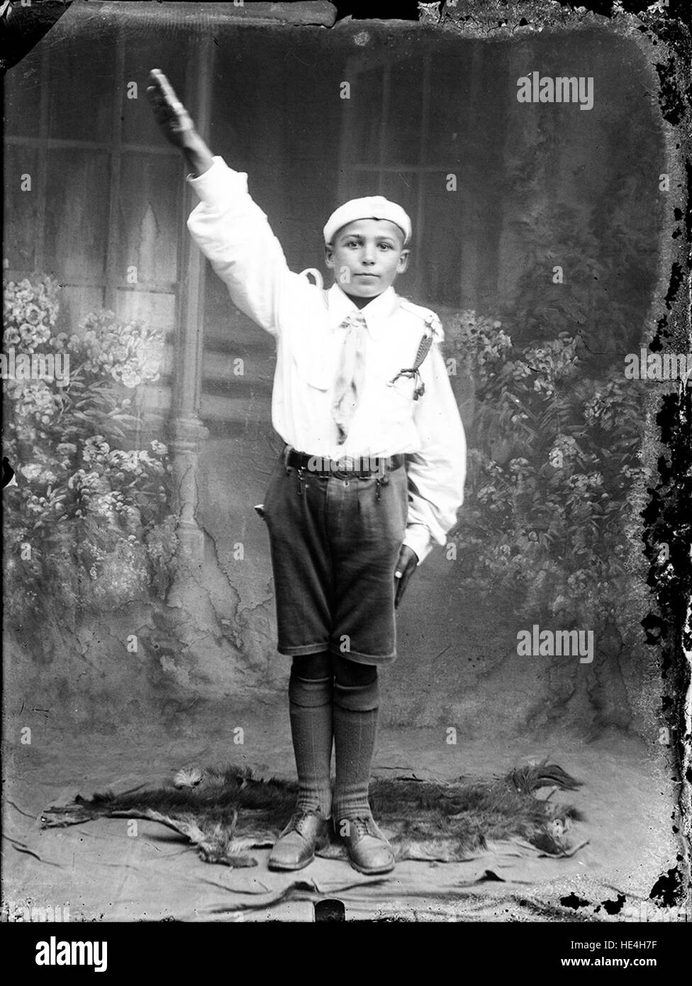 Una fotografia di un bambino in uniforme da scout, saluta, scattata a Ialomita, Romania, dall'Archivio Costica Acsinte, che mostra la storica vita rurale. Foto Stock