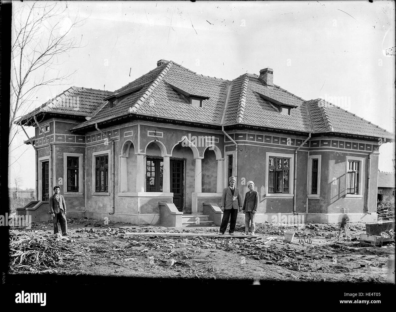 Tre persone di fronte a una casa, Romania, 1940, Archivio Costica Acsinte, Ialomita, Romania, fotografia in bianco e nero, inizio del XX secolo, vita rurale, storia rumena, ritratto di famiglia, Romania storica, regione di Ialomita, vetro negativo, Costica Acsinte, abbigliamento tradizionale rumeno, personaggi storici, Romania rurale, fotografia d'archivio, Romania degli anni '1940, patrimonio rumeno, storia sociale, foto storica, cultura rumena, abbigliamento tradizionale rumeno, Romania rurale, archivio Costica Acsinte, famiglia rumena, foto di famiglia, vita rurale rumena, ritratto rurale Foto Stock