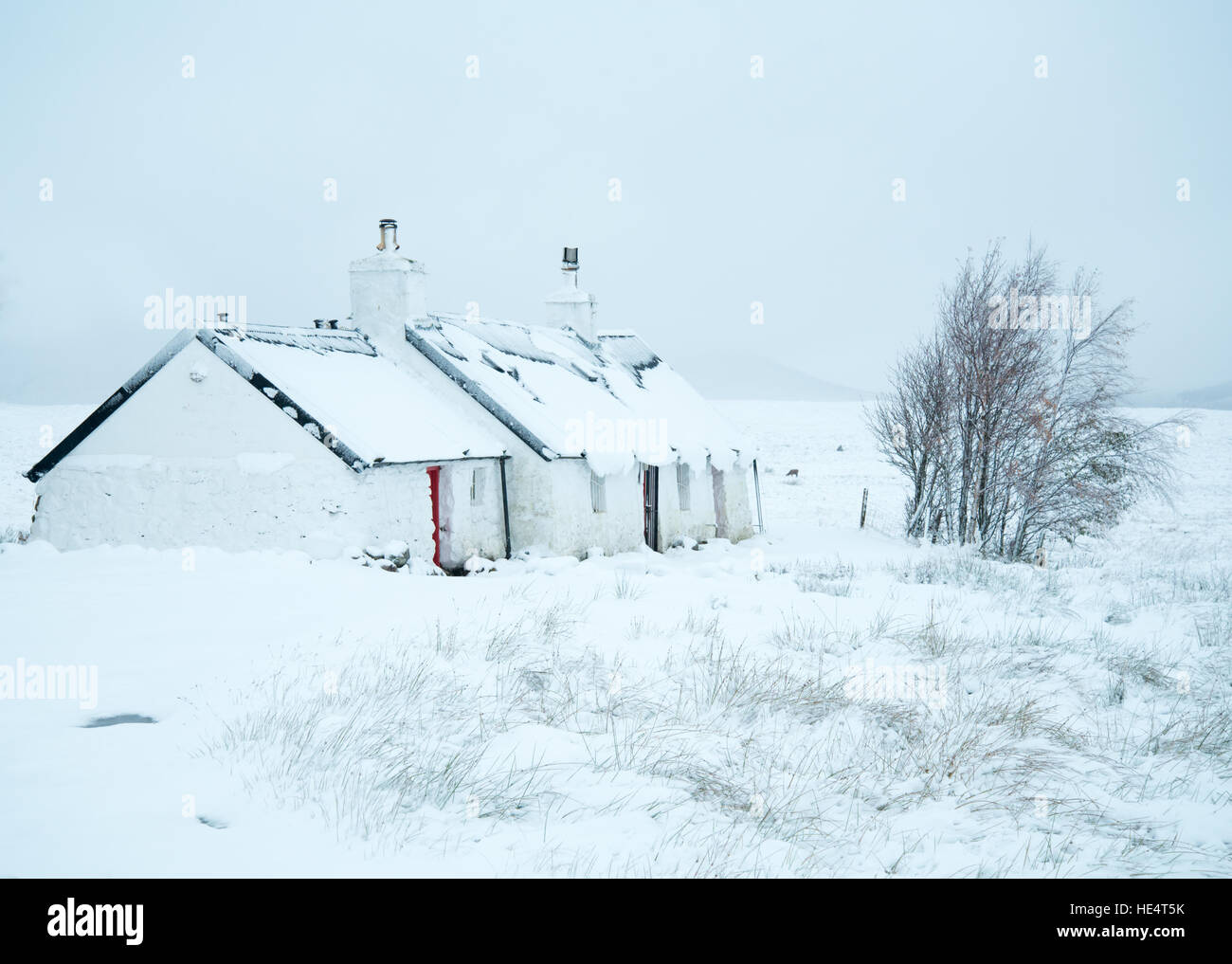 Tradizionale casa scozzese per la West Highland Way sentiero su Rannoch Moor, Glencoe all'inizio dell'inverno la neve. La Scozia, Regno Unito Foto Stock