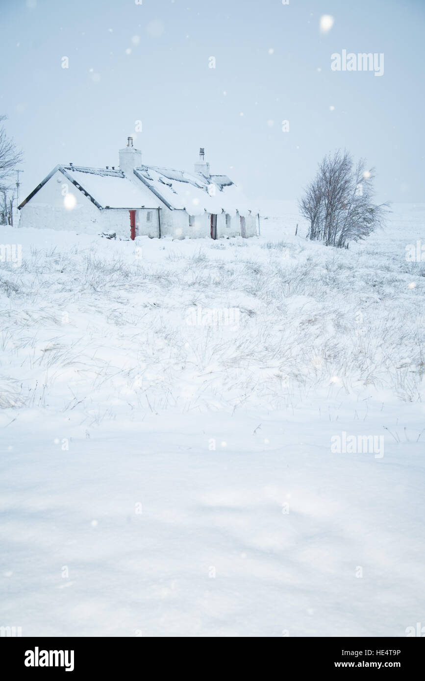 Tradizionale casa scozzese per la West Highland Way sentiero su Rannoch Moor, Glencoe all'inizio dell'inverno la neve. La Scozia, Regno Unito Foto Stock