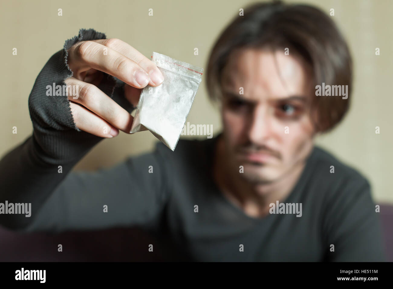 L'uomo con la dose di cocaina in mano. Foto Stock